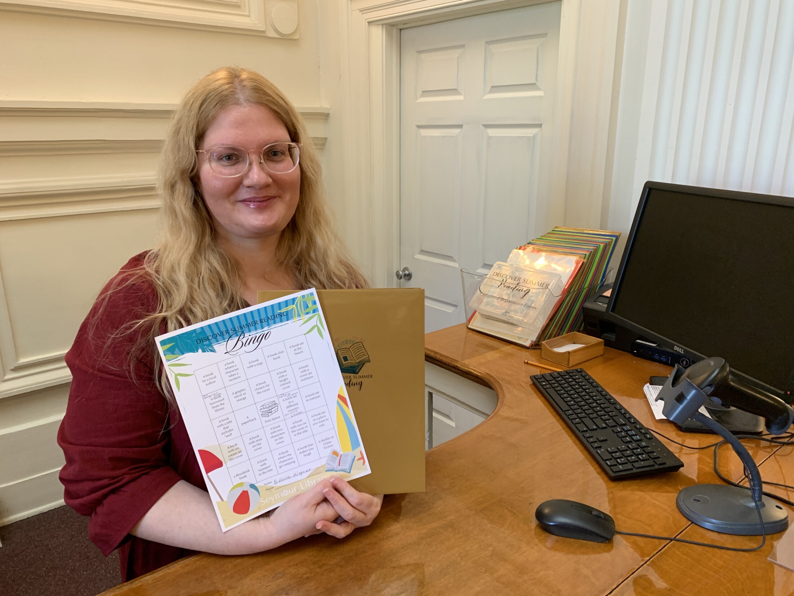 Stop by for your Discover Summer Folder and enroll in the Adult Summer Reading Program at Seymour Library! Image of staff member holding up the Summer Reading kit.